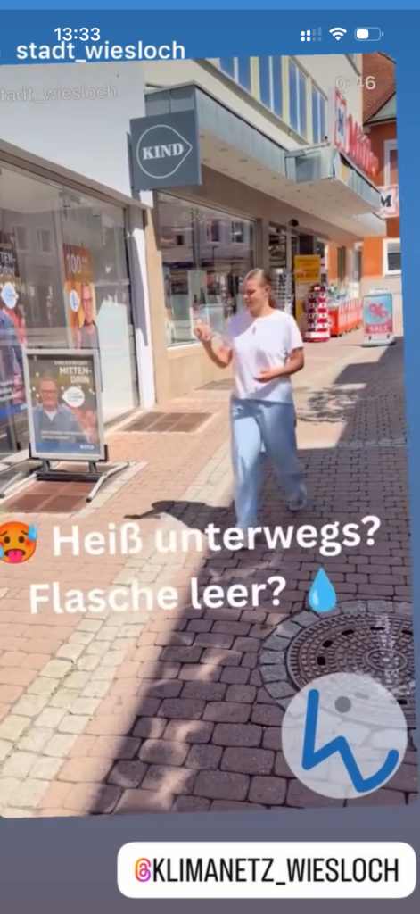 Die erste Abbildung zeigt die Hauptstraße von Wiesloch und eine junge Frau, die bei hochsommerlichen Temperaturen mit einer leeren Trinkflasche ein Geschäft betritt, um dort die Trinkflasche mit frischem Leitungswasser auffüllen zu lassen.